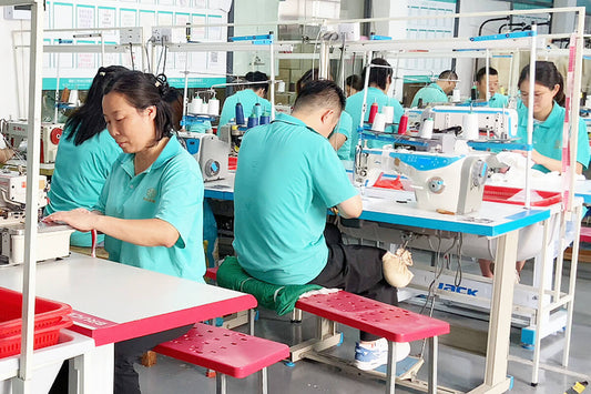 Baby clothing production line at Muhong Apparel factory showing cutting, sewing, and finishing stations