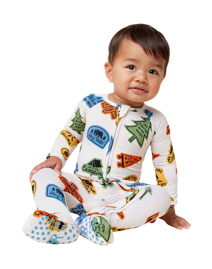 Baby sitting wearing bamboo viscose footed zip sleepsuit with adventure badge print - Alice Apparel