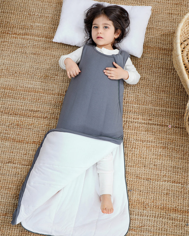 Baby in a gray cotton sleep sack showing the roomy lower-body design