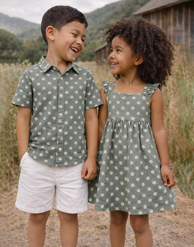 Brother and sister wearing matching sage green polka dot shirt and dress outdoors - Alice Apparel