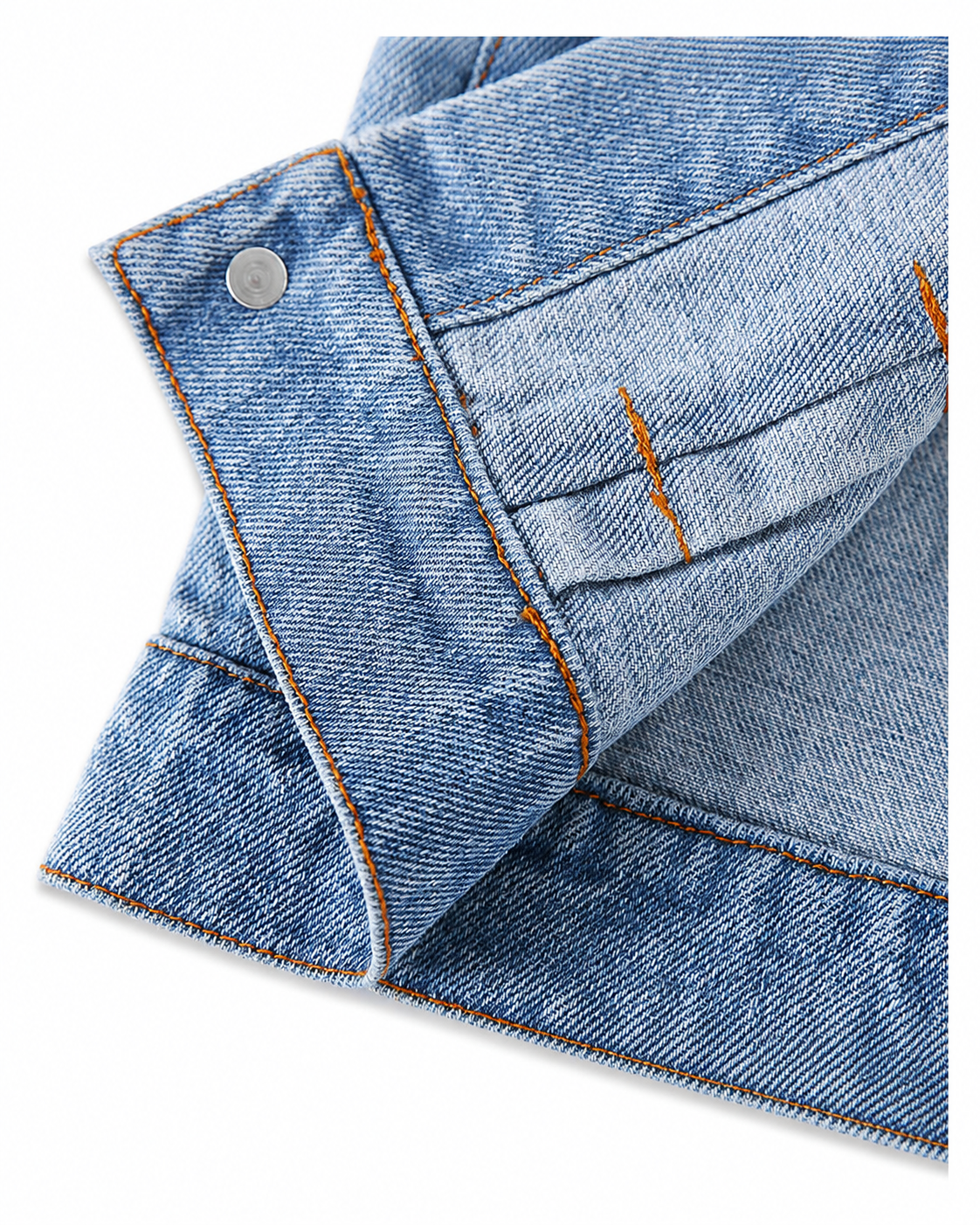 Close-up of washed denim fabric, contrast stitching and button details on a baby jacket