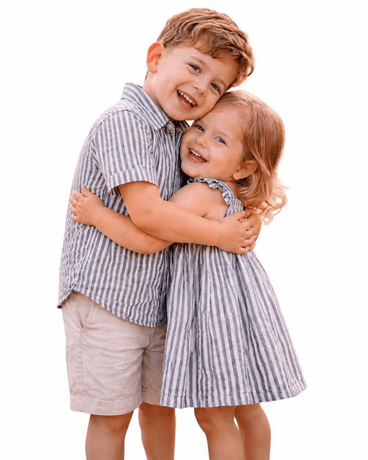 Boy and girl wearing blue striped sibling matching shirt and dress