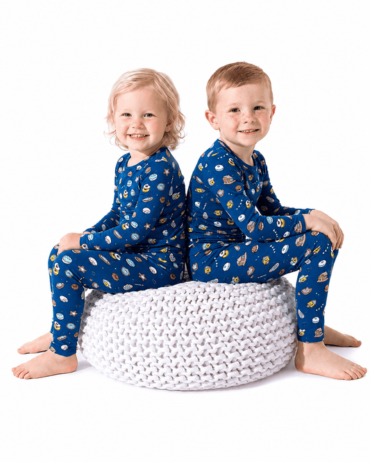 Children wearing blue sibling matching long sleeve pajama sets