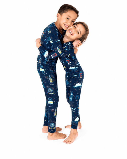 Children wearing navy space print sibling matching long sleeve pajamas