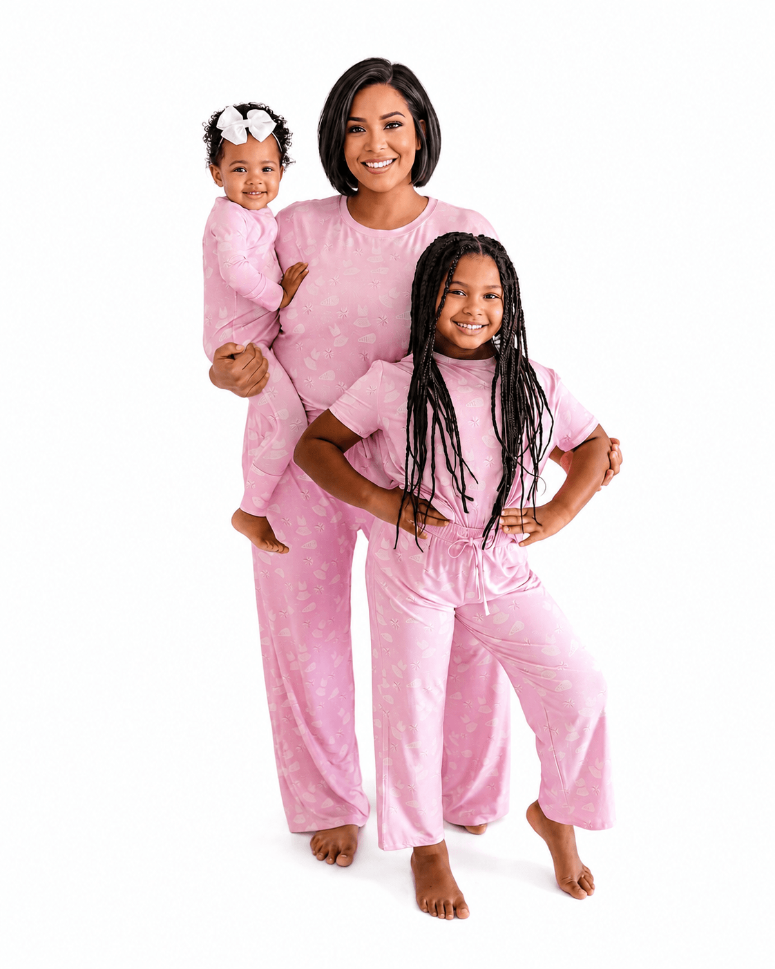 Woman and two girls wearing blush pink matching family pajamas