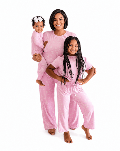 Woman and two girls wearing blush pink matching family pajamas