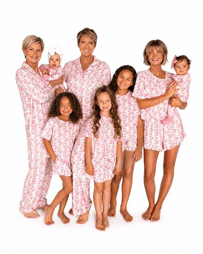 Women, girls, and babies wearing blush pink bow print matching family pajamas