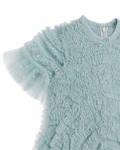 Close-up of the textured fabric and layered tulle sleeve on a girls light blue party dress