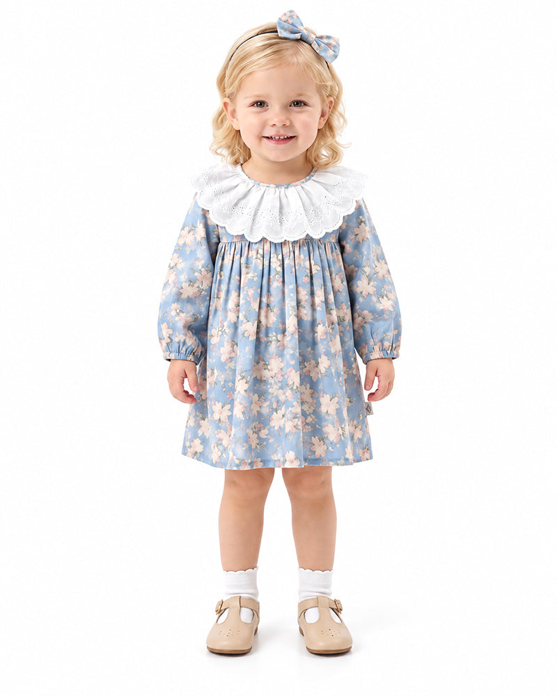 Girl wearing blue floral dress with oversized white ruffle collar