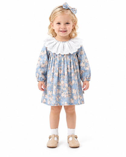 Girl wearing blue floral dress with oversized white ruffle collar