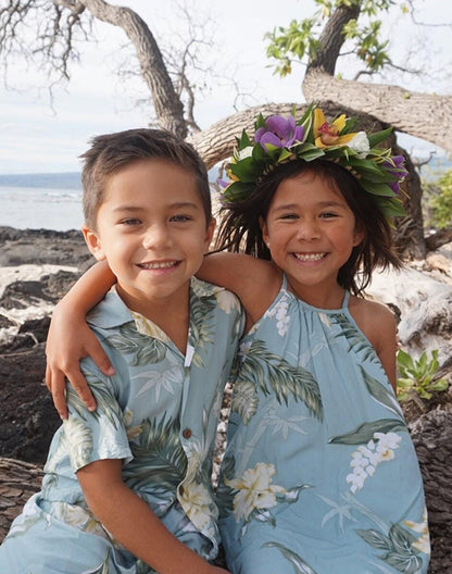 Brother and sister wearing matching tropical floral Hawaiian outfits at the beach - Alice Apparel