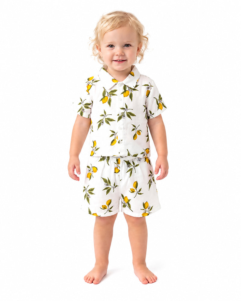 Child wearing lemon print short sleeve shirt and shorts set