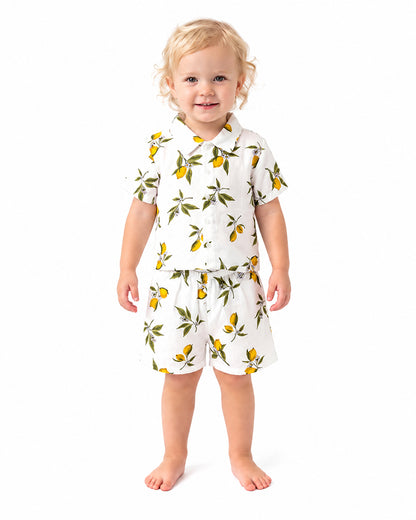 Child wearing lemon print short sleeve shirt and shorts set