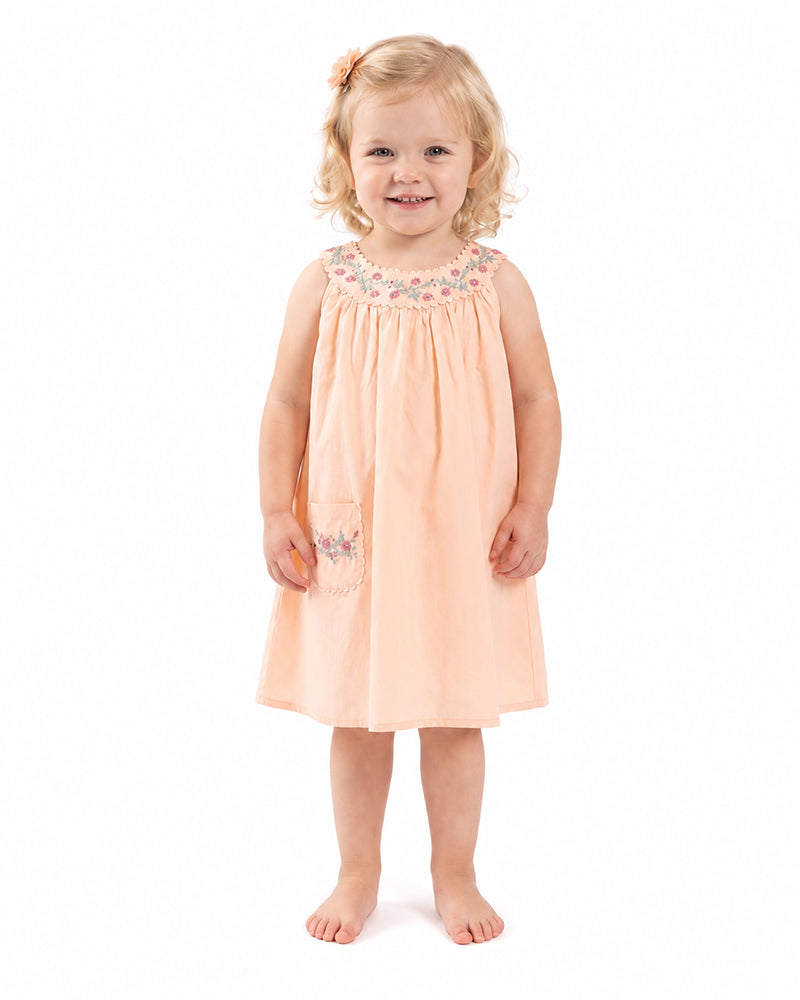 Girl wearing peach sleeveless gathered neckline dress
