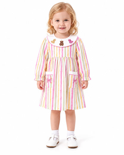 Girl wearing pastel stripe long sleeve dress with front pockets