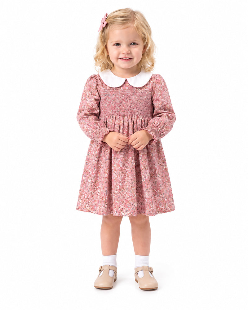 Girl wearing pink floral smocked Peter Pan collar dress