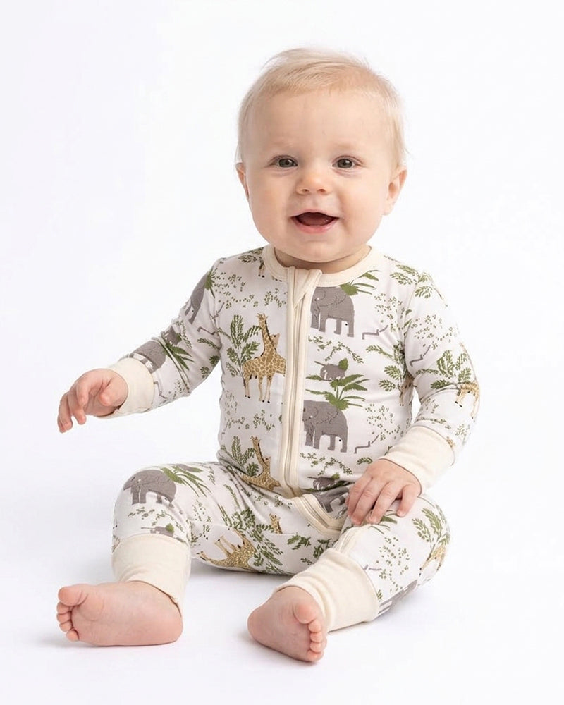 Baby sitting in woodland print one-piece pajama romper