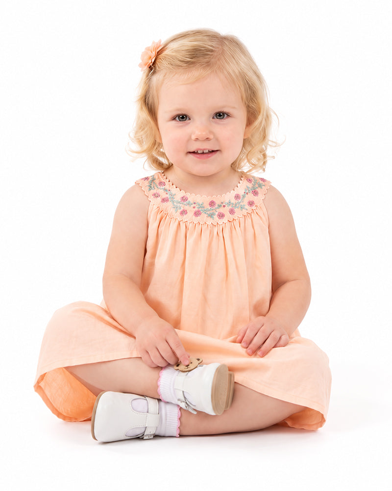 Girls soft peach A-line dress with decorative neckline detail