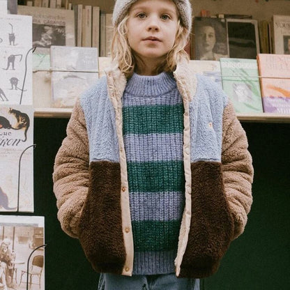 Girl wearing a color block sherpa fleece jacket with a stand collar and front pockets