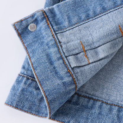 Close-up of washed denim fabric, contrast stitching and button details on a baby jacket