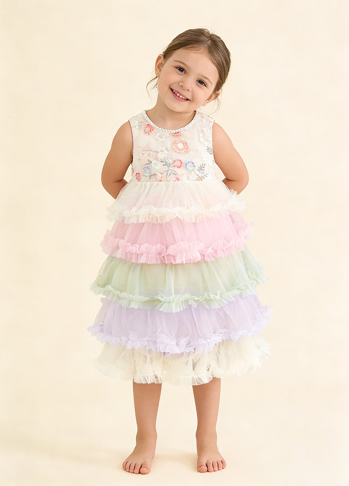 Girl wearing a pastel tiered tulle ruffle dress with a floral sleeveless bodice