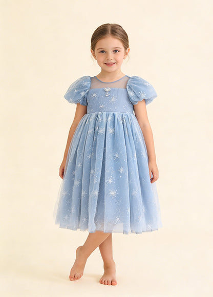 Girl wearing a blue snowflake tulle party dress with short puff sleeves