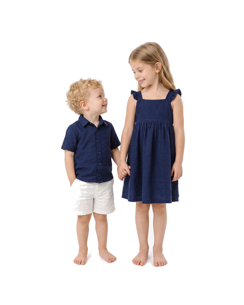 Boy and girl wearing navy blue sibling matching shirt and dress outfits